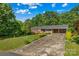 Well-maintained brick home featuring a convenient carport and a lush, green front yard with mature trees at 157 E Meadowview Dr, Statesville, NC 28625