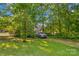 Lush front yard with a parked car surrounded by mature trees and green grass at 157 E Meadowview Dr, Statesville, NC 28625