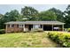 Charming brick home featuring a carport and a cozy front porch surrounded by lush landscaping at 157 E Meadowview Dr, Statesville, NC 28625