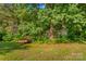 An exterior shot of a shed on a lush lot shows ample opportunities for storage and outdoor activities at 157 E Meadowview Dr, Statesville, NC 28625
