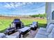 Cozy back patio with plush seating surrounding the stone fireplace and manicured lawn at 174 Hanks Bluff Dr, Mooresville, NC 28117