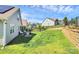 Expansive backyard with lush green grass, a stone fire pit, and wrought iron fencing at 174 Hanks Bluff Dr, Mooresville, NC 28117