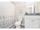 Well-lit full bathroom with granite countertop, white cabinets, and shower with patterned curtain at 174 Hanks Bluff Dr, Mooresville, NC 28117