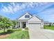 Charming home with a two-car garage, landscaped yard and a cozy porch under a sunny blue sky at 174 Hanks Bluff Dr, Mooresville, NC 28117