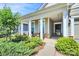 Inviting covered front porch with stone accents and charming seating area at 174 Hanks Bluff Dr, Mooresville, NC 28117