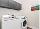 This is a laundry room that has a front loading washer and dryer with storage cabinets above at 174 Hanks Bluff Dr, Mooresville, NC 28117