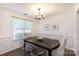Bright dining room showcasing wood floors, chair rail, and modern chandelier at 18629 Coachmans Trce, Cornelius, NC 28031