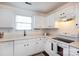 Well-lit kitchen with white cabinets, modern appliances, and ample counter space for cooking at 18629 Coachmans Trce, Cornelius, NC 28031