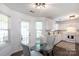 Bright eat-in kitchen featuring white cabinetry, updated appliances, and a modern glass-top dining table at 18629 Coachmans Trce, Cornelius, NC 28031