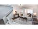 Stylish living room with hardwood floors, featuring a staircase and view of kitchen at 18629 Coachmans Trce, Cornelius, NC 28031