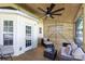 Inviting covered porch featuring wicker furniture, ceiling fan, and natural wood accents for relaxed outdoor living at 18629 Coachmans Trce, Cornelius, NC 28031