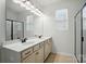 Bathroom featuring double sink vanity and a large mirror with lighting fixtures, with a shower on the right at 1957 Tablerock Dr # 59, York, SC 29745