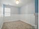 A well-lit bedroom with board and batten accent, featuring a window and plush carpeting at 1957 Tablerock Dr # 59, York, SC 29745