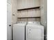 Laundry room with convenient wooden shelves and appliances against a white and tan patterned wallpaper at 1957 Tablerock Dr # 59, York, SC 29745