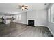 Open concept living room with fireplace and modern gray wood-look flooring, open to kitchen with white cabinetry at 1957 Tablerock Dr # 59, York, SC 29745