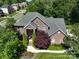 An aerial view shows a brick home with mature landscaping and tree coverage in a residential neighborhood at 201 Vanderbilt Blvd, Locust, NC 28097