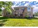 Brick home with back patio, green lawn, mature trees, and lush landscaping at 201 Vanderbilt Blvd, Locust, NC 28097