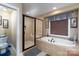 This bathroom features a glass-enclosed shower, soaking tub, and neutral tile work at 201 Vanderbilt Blvd, Locust, NC 28097