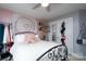 A modern bedroom featuring pink accent wall and storage solutions and a comfortable bed at 201 Vanderbilt Blvd, Locust, NC 28097