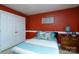 This bedroom has stylish decor, including a modern lamp, a cozy bed, and a vibrant red accent wall at 201 Vanderbilt Blvd, Locust, NC 28097