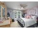 Well-lit bedroom with a ceiling fan, large windows, neutral walls, a decorative tapestry and comfortable furnishings at 201 Vanderbilt Blvd, Locust, NC 28097