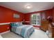 A cozy bedroom features vibrant red walls, complementing a comfortable bed and a bright, sunlit window at 201 Vanderbilt Blvd, Locust, NC 28097