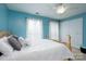 Light and airy bedroom featuring a neutral palette, ceiling fan, and bright natural light through dual windows at 201 Vanderbilt Blvd, Locust, NC 28097