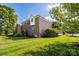 A brick home with lush green lawn and mature trees in a quiet neighborhood at 201 Vanderbilt Blvd, Locust, NC 28097