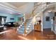 Open foyer with hardwood floors, staircase with white railing and view into the living room at 201 Vanderbilt Blvd, Locust, NC 28097