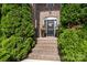 Charming brick home entryway with a decorative wreath on the front door and surrounded by lush greenery at 201 Vanderbilt Blvd, Locust, NC 28097