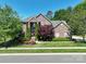 Charming two-story brick home with well-manicured lawn, mature trees, and lovely landscaping at 201 Vanderbilt Blvd, Locust, NC 28097