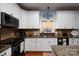 Kitchen featuring white cabinetry, a black microwave, granite counters, and hardwood floors at 201 Vanderbilt Blvd, Locust, NC 28097