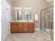 Bathroom offers double vanity, walk-in shower, neutral tile, and arched mirrors at 2301 Keara Way, Charlotte, NC 28270