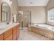 Bright bathroom featuring a double sink vanity, a soaking tub and a tiled walk in shower at 2301 Keara Way, Charlotte, NC 28270