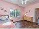 Comfortable bedroom featuring a window offering plenty of natural light, a dresser and hardwood floors at 2301 Keara Way, Charlotte, NC 28270