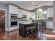 Bright kitchen features a dark island with bar seating, stainless steel appliances and hardwood floors at 2301 Keara Way, Charlotte, NC 28270