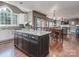 Open concept kitchen features a black island, dining table and hardwood floors throughout at 2301 Keara Way, Charlotte, NC 28270