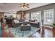 Open concept living room with plush gray sectional sofa, dining table and hardwood floors at 2301 Keara Way, Charlotte, NC 28270