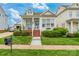 Charming two-story home with a inviting front porch, brick steps, landscaped yard, and a blue door at 23128 Goose Down Ln, Lancaster, SC 29720