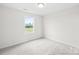 Well-lit bedroom featuring neutral walls, carpeted floors, and a view of the outdoors at 2322 Joes Lake Rd, Shelby, NC 28152