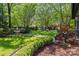 Lush backyard with stone pathway, mature trees, and comfortable seating, creating a serene outdoor space at 2329 Club Rd, Charlotte, NC 28205