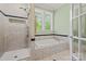 Bathroom featuring a soaking tub, tiled shower, and natural light from the window at 2329 Club Rd, Charlotte, NC 28205