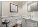 Elegant powder room featuring wainscoting, marble countertop, and decorative wall art at 2329 Club Rd, Charlotte, NC 28205