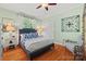 Comfortable bedroom featuring stylish blue accents, hardwood floors, and a bright window for natural light at 2329 Club Rd, Charlotte, NC 28205