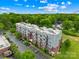 Modern condo building with a parking lot and lush green trees, offering a blend of urban living and natural beauty at 2338 Yadkin Ave # D302, Charlotte, NC 28205