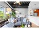 Bright living space with a cozy gray sofa, exposed ceilings, and a view of the dining area and kitchen at 2338 Yadkin Ave # D302, Charlotte, NC 28205
