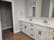 Bright bathroom featuring a double vanity with white cabinets and hard wood floors at 2442 Falcon Ln, Statesville, NC 28625