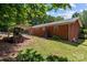 Backyard featuring a brick home, a detached carport, and green landscaping at 24501 Canton Rd, Albemarle, NC 28001