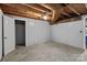 Spacious unfinished basement with concrete floor and doorway into separate storage area at 24501 Canton Rd, Albemarle, NC 28001
