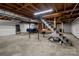 Unfinished basement with exposed ceiling, concrete floor, staircase, brick feature, and blue sports car at 24501 Canton Rd, Albemarle, NC 28001